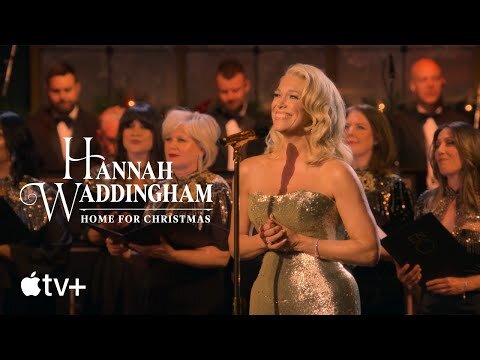 Hannah Waddingham sings center stage in a sparkly strapless dress, backed by a choir, warm lighting, and the Apple TV+ logo.