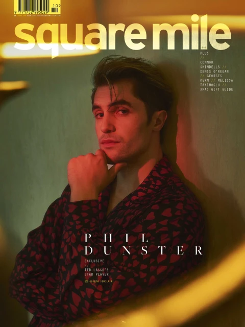 Magazine cover featuring Phil Dunster in a patterned robe against a muted background with warm lighting and "square mile" title.