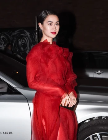 Woman in a sheer red dress posing next to a silver car in New York styled by Jared Depriest