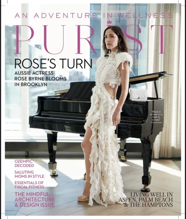 Magazine cover featuring Rose Byrne in a ruffled dress, alongside a piano and article titles, set against a city background.
