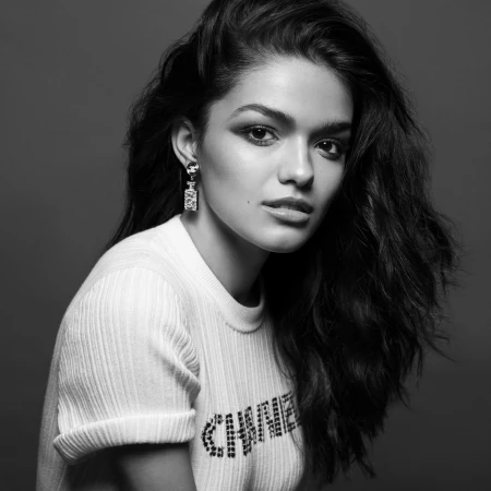 Monochrome portrait of a woman with dark wavy hair wearing a white top and drop earrings styled by Jared Depriest