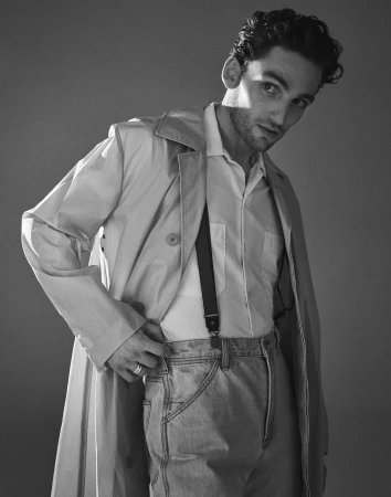 Black and white portrait of a man wearing a trench coat, button-down shirt, and suspenders in New York.