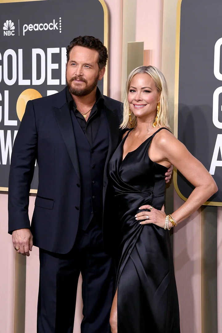 Brandon Boyd and Jennie Garth at the Golden Globes Awards, posing in formal attire against a branded backdrop, indoor event.