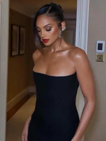 Woman wearing a strapless black dress, red lipstick, and ornate ear cuff with hair styled by Jay B in London.
