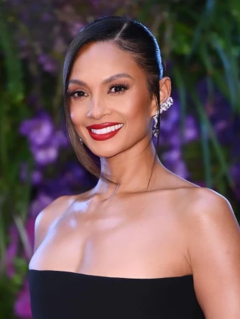 Portrait of a woman wearing a black strapless dress with red lipstick and an elaborate ear cuff against a floral background