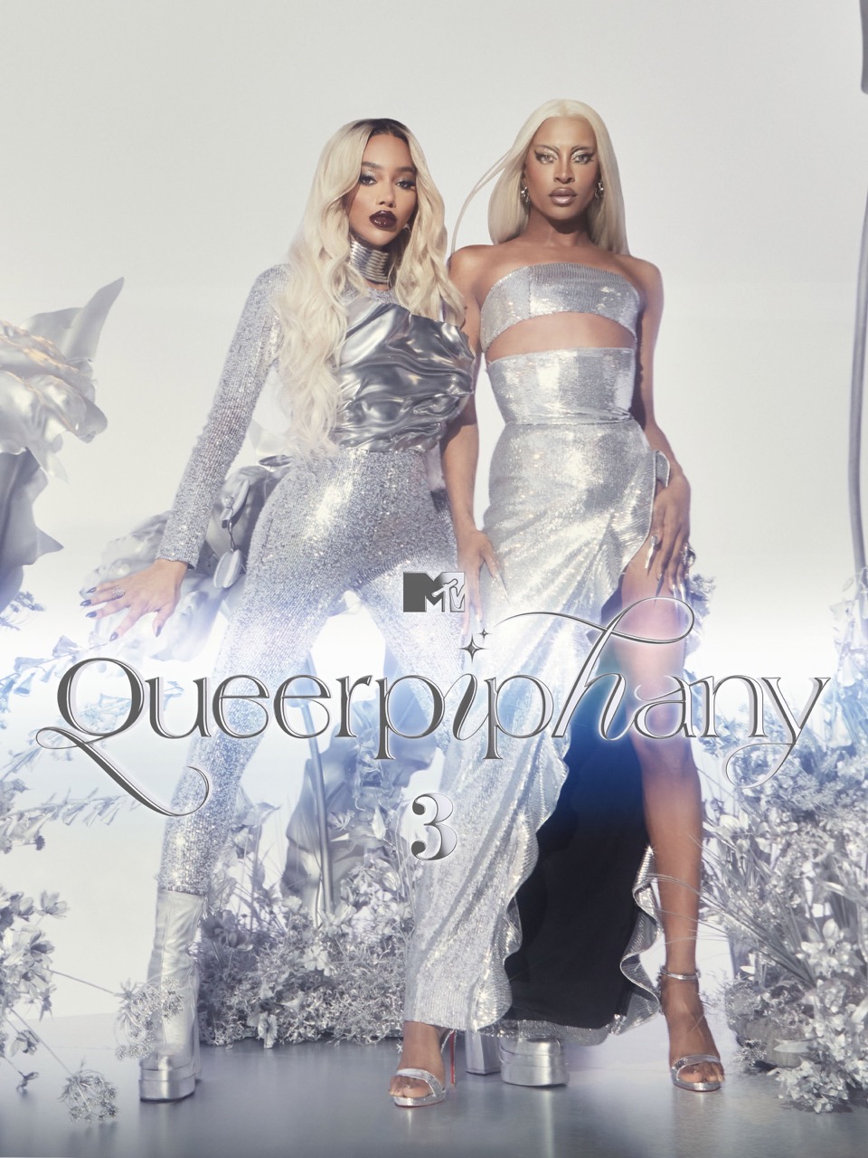 Two women in shimmering silver gowns pose in a studio. The image promotes 'Queerphipany 3' and features the MTV logo. The background is bright white.