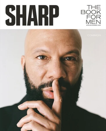 Close-up portrait of American rapper and actor Common with finger held to lips, styled by Jay Hines
