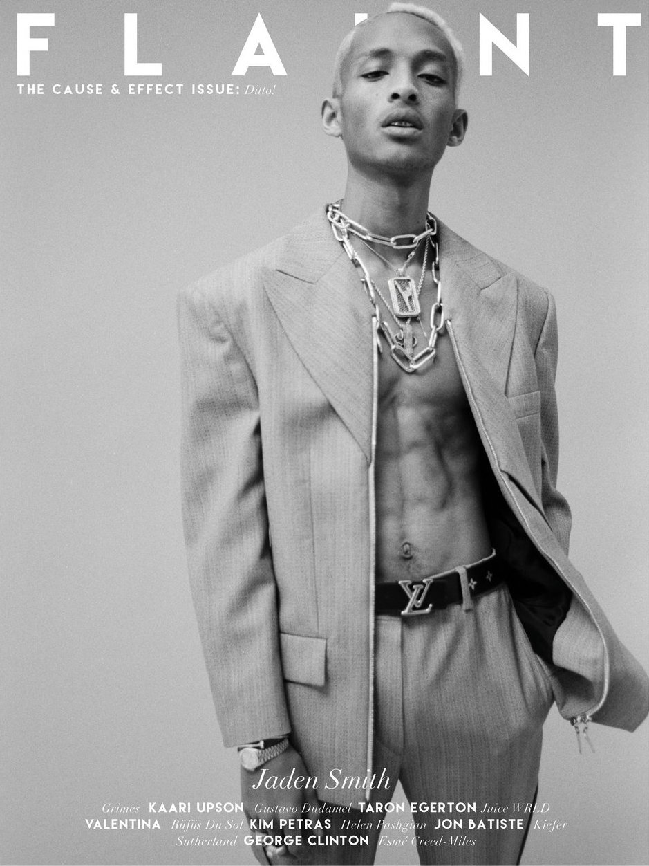 Monochrome portrait of Jaden Smith wearing a blazer with no shirt, chain necklaces, belt with a logo, and a watch. Magazine cover.