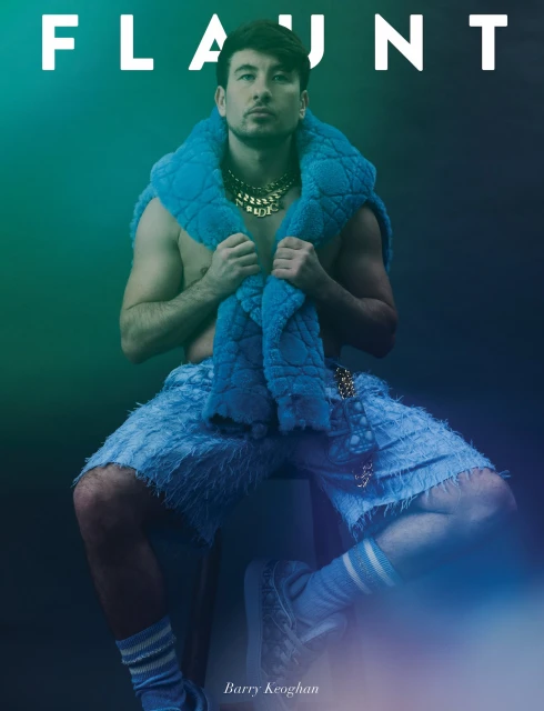 Flaunt Magazine cover features Barry Keoghan in textured blue outfit and gold chain, seated against a gradient teal backdrop.