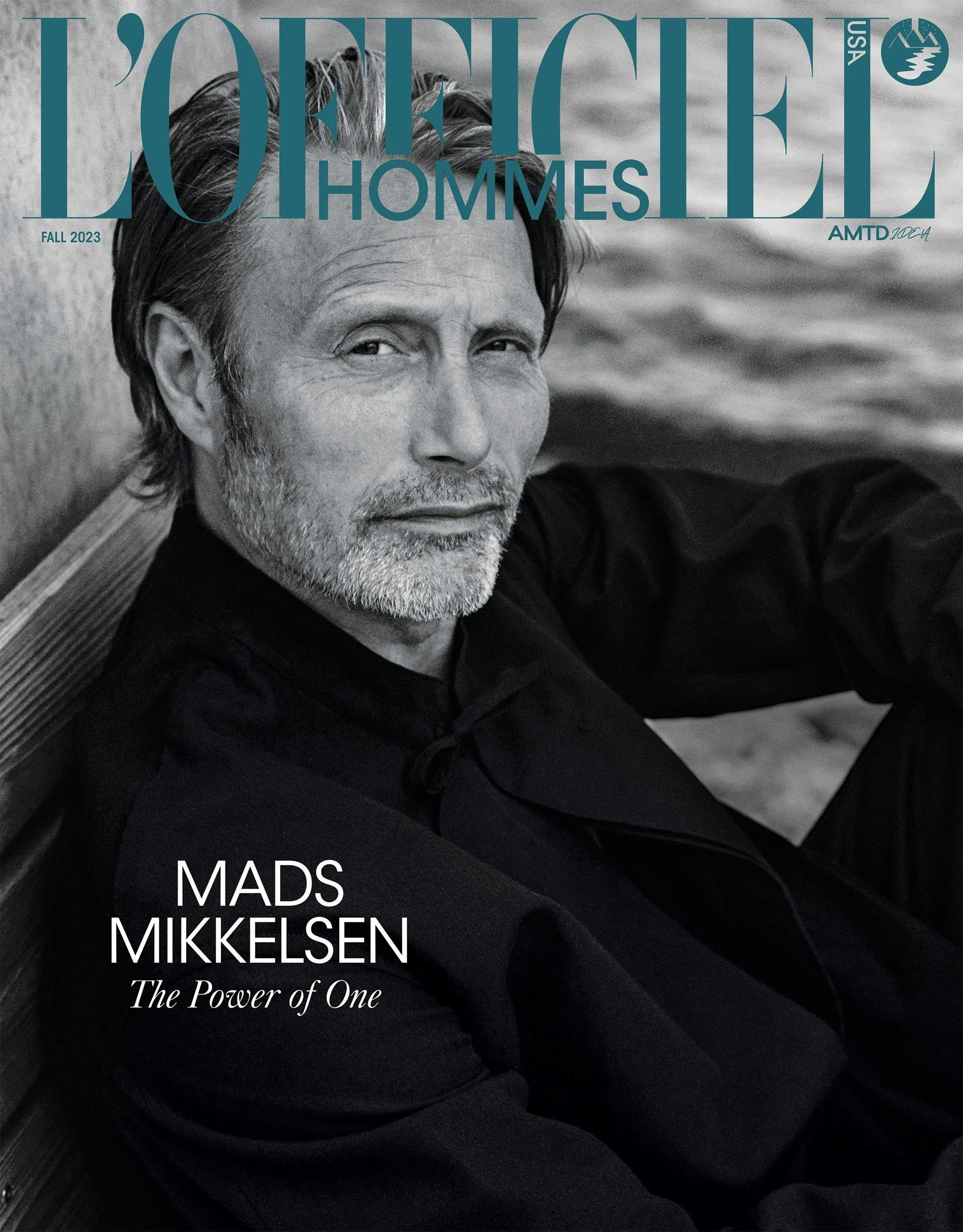 Magazine cover featuring a portrait of Mads Mikkelsen in a dark coat, with the magazine's title "L'Officiel Hommes" displayed prominently.