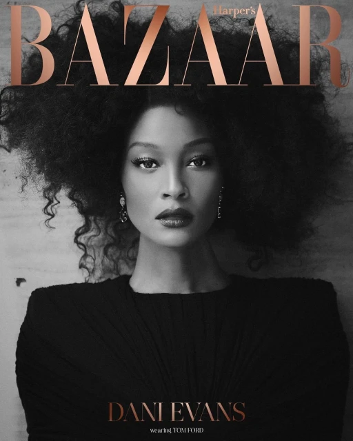 Close-up fashion portrait on magazine cover. Dani Evans poses with afro, wearing a black dress, against neutral background, with Bazaar masthead.