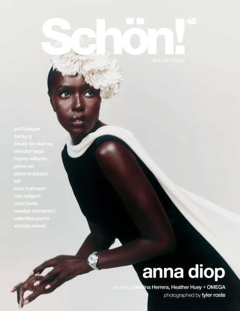 Magazine cover featuring a Black woman wearing a black dress and a white flower headpiece against a pale backdrop in a studio shot.
