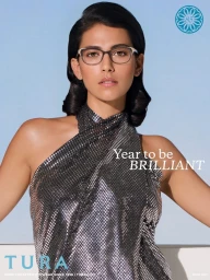Woman wearing eyeglasses and a metallic halter dress against a clear blue sky background