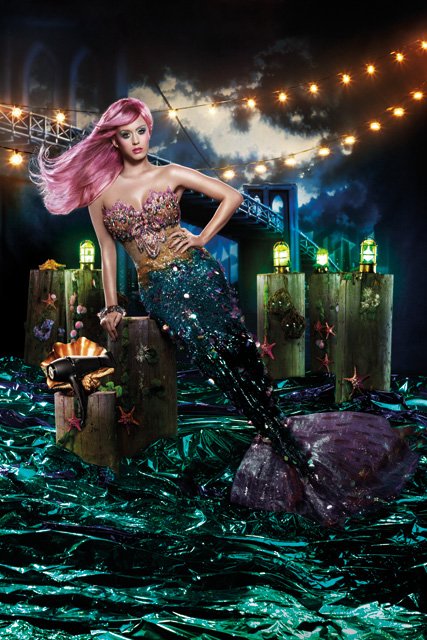 Glamorous mermaid in sequined tail poses near vintage spotlights, stage elements, and teal backdrop, evoking fantasy and artistic flair.