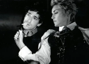 Black and white portrait of Adrien Brody smoking a cigarette next to Sharon Stone styled by Johnny Wujek