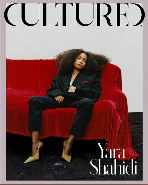 Magazine cover featuring Yara Shahidi sitting on a red velvet couch, wearing a pinstripe suit and nude heels against a neutral backdrop.