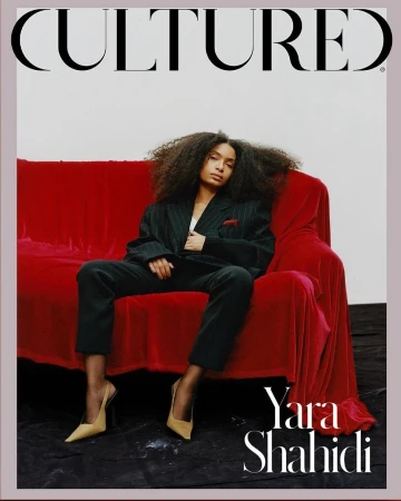 Magazine cover featuring Yara Shahidi sitting on a red velvet couch, wearing a pinstripe suit and nude heels against a neutral backdrop.