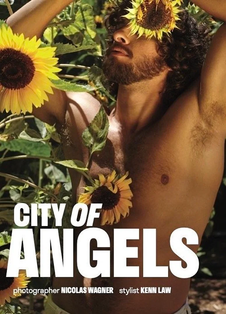 Bare-chested adult man surrounded by sunflowers poses in an outdoor fashion shot; bright light and bold sans-serif text overlay image.