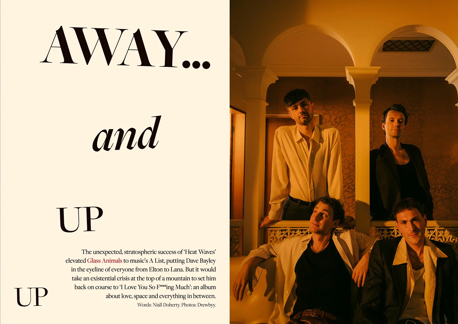 Four men pose indoors in front of a warm-toned arched wall with patterned wallpaper, creating a music band promotional shot.