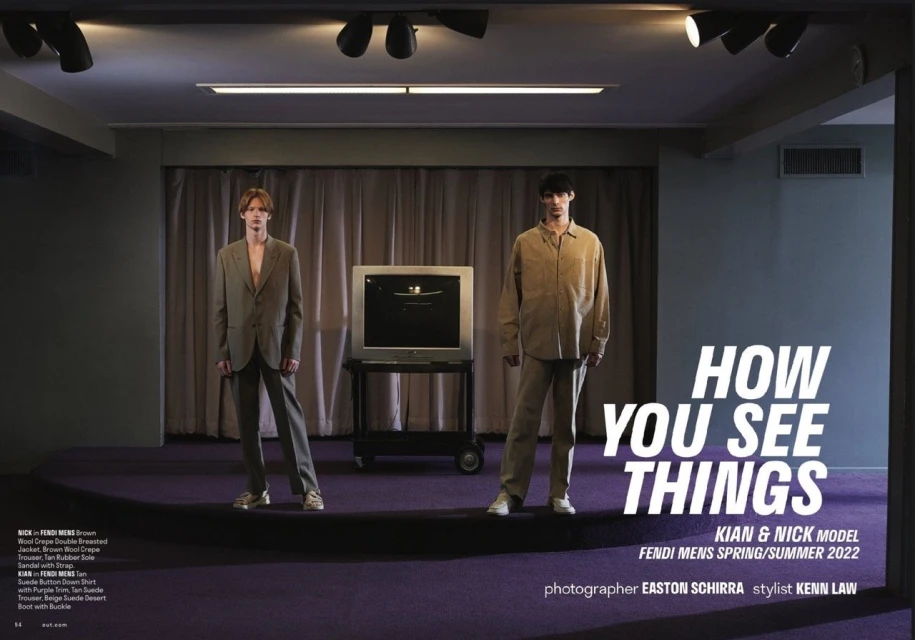 Two male models showcase Fendi menswear spring/summer 2022 in a photo studio setting with a retro television, promoting fashion editorial style.
