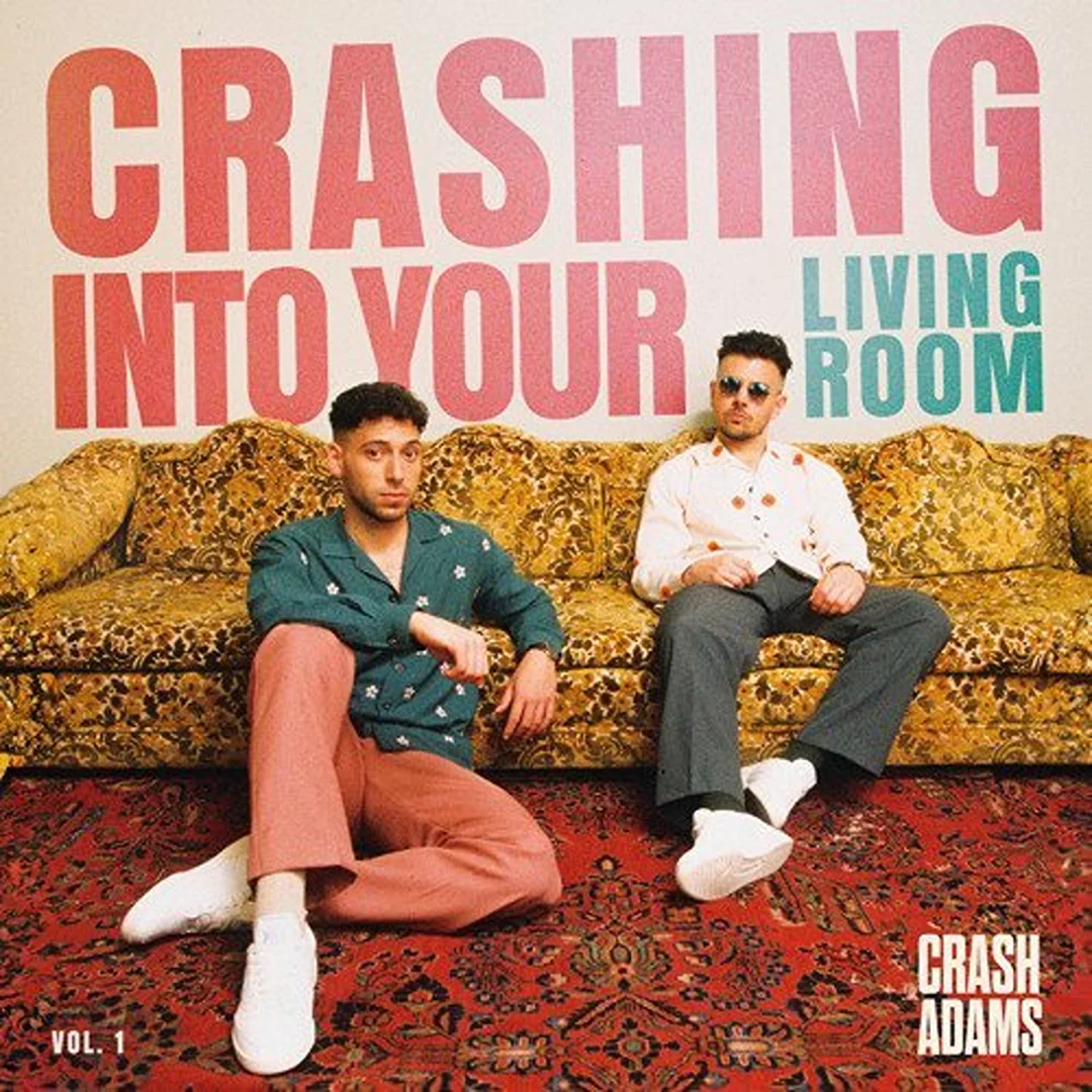 Album cover featuring musical duo Crash Adams sitting on a vintage couch against a white wall with overlaid lettering.