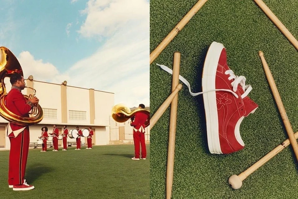 Red One Star Converse shoe displayed on green astroturf with drumsticks. On the left, band members in red outfits play instruments.