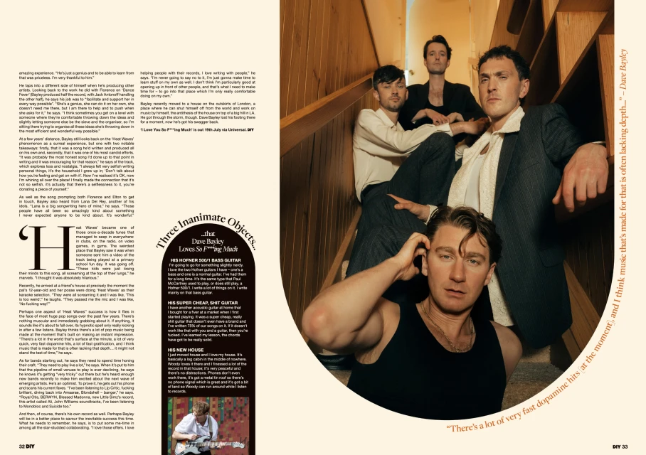Indoor portrait of a five-man band on stairs in a warm, editorial style. Band members wear diverse outfits, including a suit, t-shirt, and tank top.