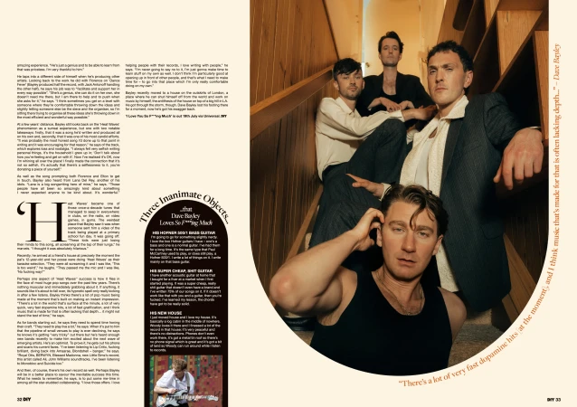 Indoor portrait of a five-man band on stairs in a warm, editorial style. Band members wear diverse outfits, including a suit, t-shirt, and tank top.