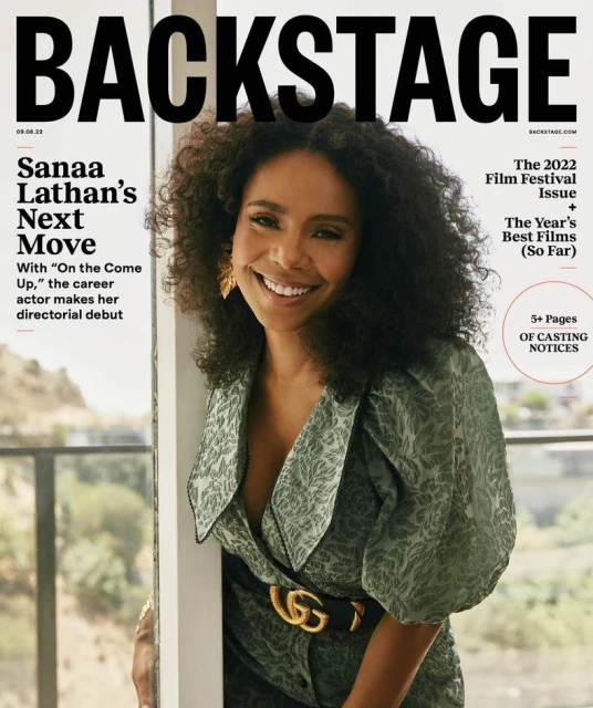 Sanaa Lathan on the cover of Backstage magazine, smiling and wearing a patterned green dress with a Gucci belt indoors.