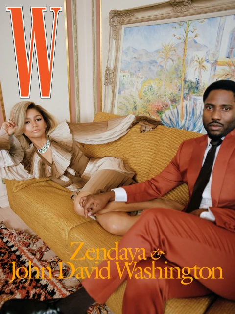 Magazine cover featuring Zendaya and John David Washington on a yellow couch with a painted backdrop in a portrait orientation.