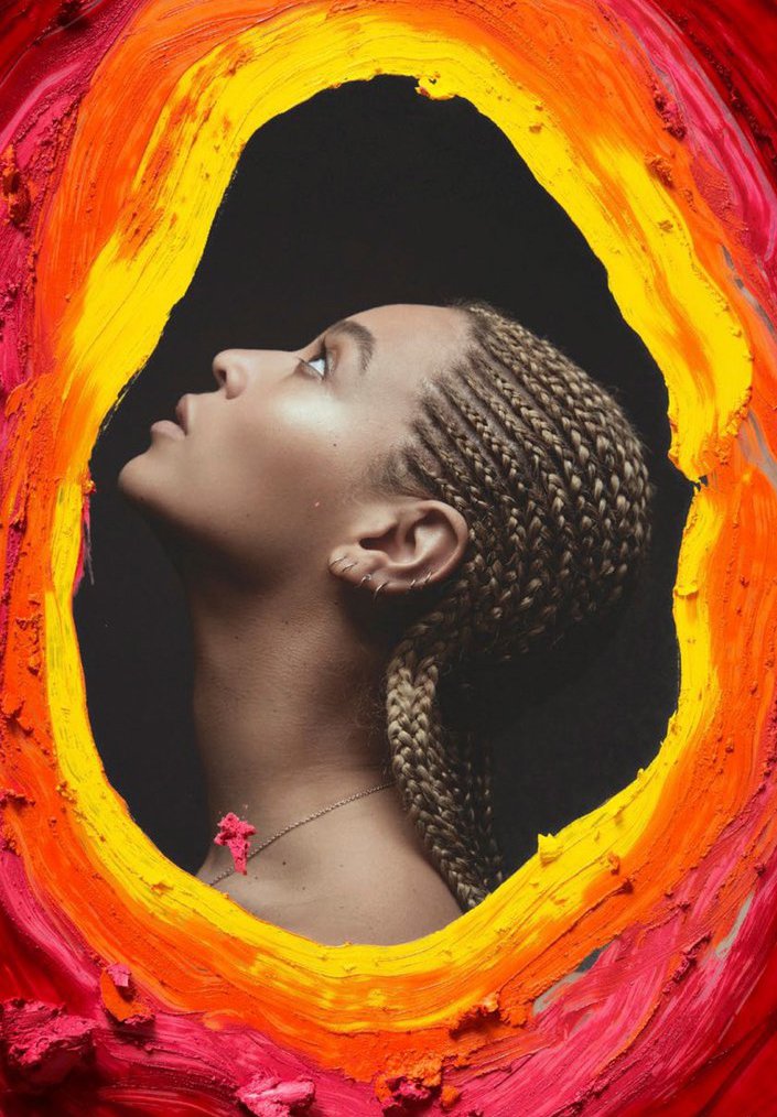 Profile shot of a woman with blonde braided hair and a red flower necklace looking upwards against a black background surrounded by painted frame.