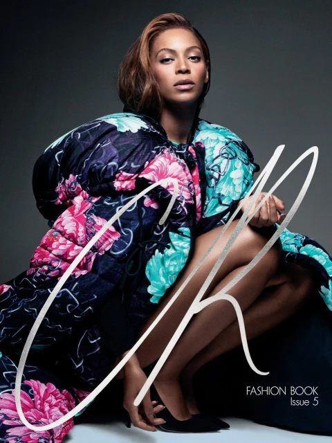 Fashion book cover featuring a model in a floral coat squatting against a grey backdrop, large stylish text overlay, fashion editorial.