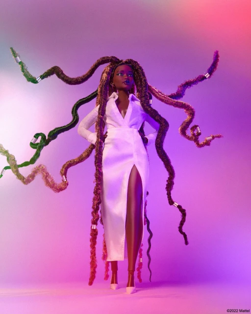 A posed fashion doll in a long white dress with an oversized collar and high slit shows long multi-colored braids with silver accents.