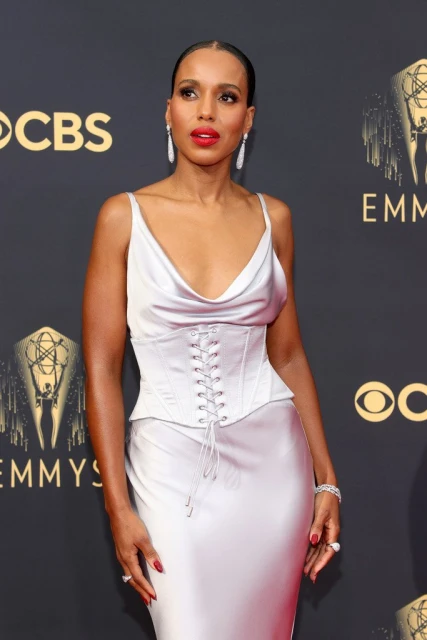 Kerry Washington on the red carpet at the Emmy Awards, wearing a silver dress with corset detailing and red lipstick.