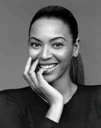 Portrait of Beyonce smiling with hand near mouth, styled by hair stylist Kim Kimble, against a grey background.