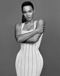 Monochrome portrait of Beyoncé in a form-fitting textured white dress with a high ponytail against a grey backdrop
