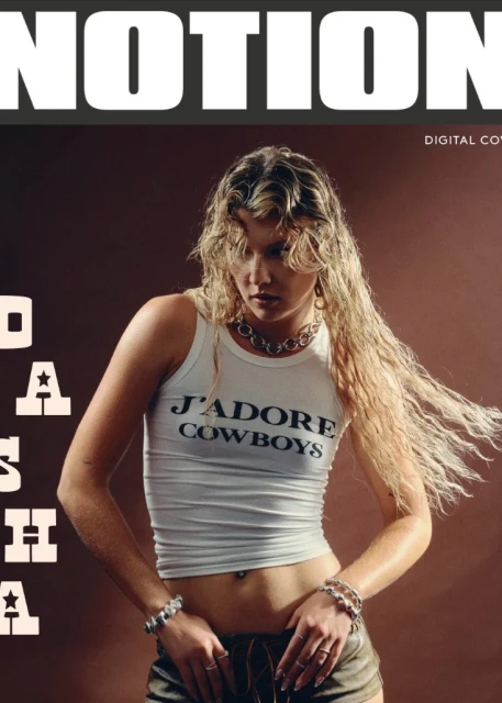 Fashion magazine cover featuring a young woman with blonde hair, wearing a tank top and shorts, posing against a brown backdrop.