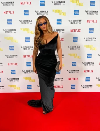 Beyonce attends the BFI London Film Festival 2021, wearing a black velvet dress, posing on the red carpet in front of a branded backdrop.