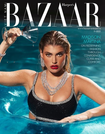 Woman in black swimsuit holding a glass in a blue pool with diamond jewelry and red lipstick by Laura Rugetti