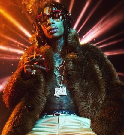 Wiz Khalifa smoking while wearing sunglasses, layered chains, and a furry brown coat, styled by Lauren Matos in Los Angeles.