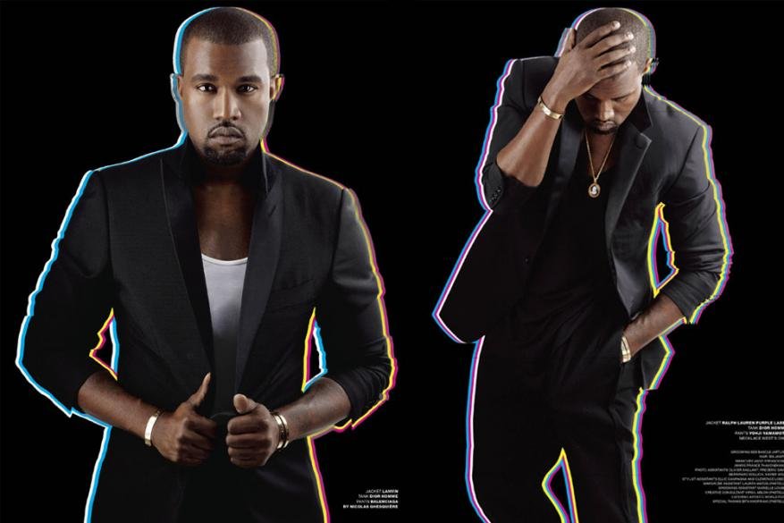 Two adult males wearing black suits pose in a studio with a black background, showcasing formal wear and fashion for an editorial photoshoot.