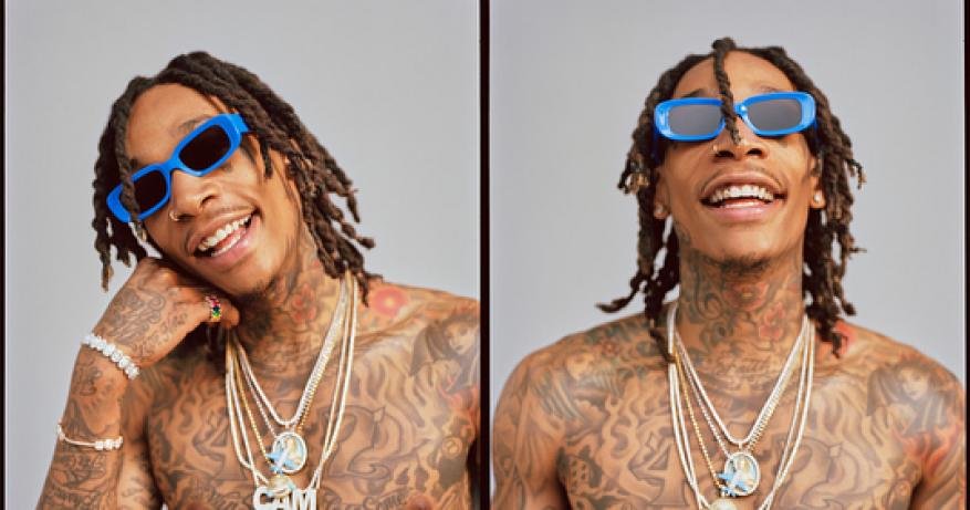 Wiz Khalifa wearing blue sunglasses and layered diamond necklaces against a neutral studio backdrop, styled by Lauren Matos