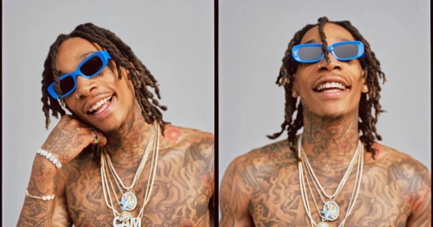Wiz Khalifa wearing blue sunglasses and layered diamond necklaces against a neutral studio backdrop, styled by Lauren Matos