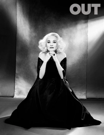 Jessica Lange in a black off-the-shoulder gown posing against a textured backdrop for an editorial portrait styled by Lauren Matos.