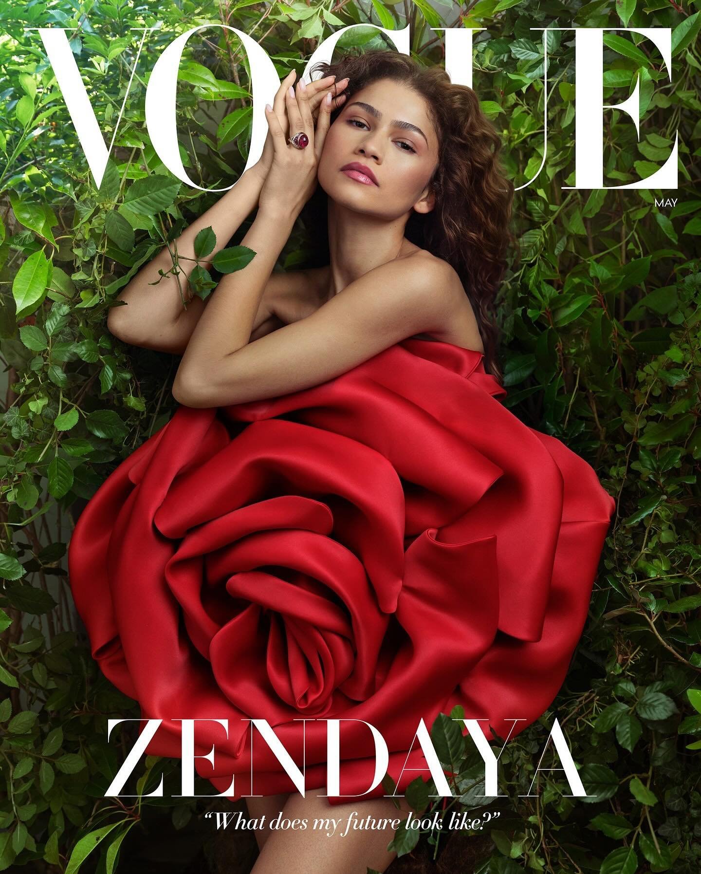 Vogue magazine cover featuring Zendaya lying in greenery, wearing a red flower dress and ring. Magazine title and text visible.