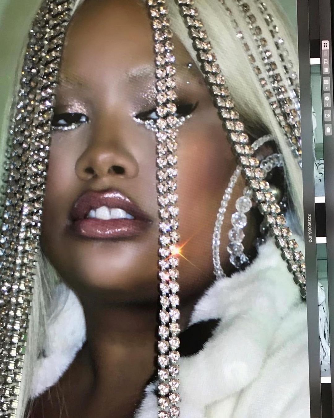 Glamorous portrait of a woman with dark skin, platinum blonde hair, diamond-like chains, and glittery makeup, close up shot, beauty.