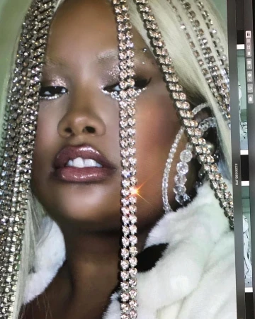 Glamorous portrait of a woman with dark skin, platinum blonde hair, diamond-like chains, and glittery makeup, close up shot, beauty.