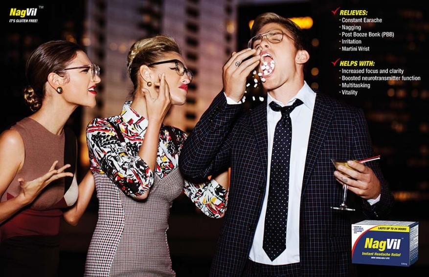 Three people: a man in a suit putting white pills in his mouth and two women beside him, with an advertisement in the background.