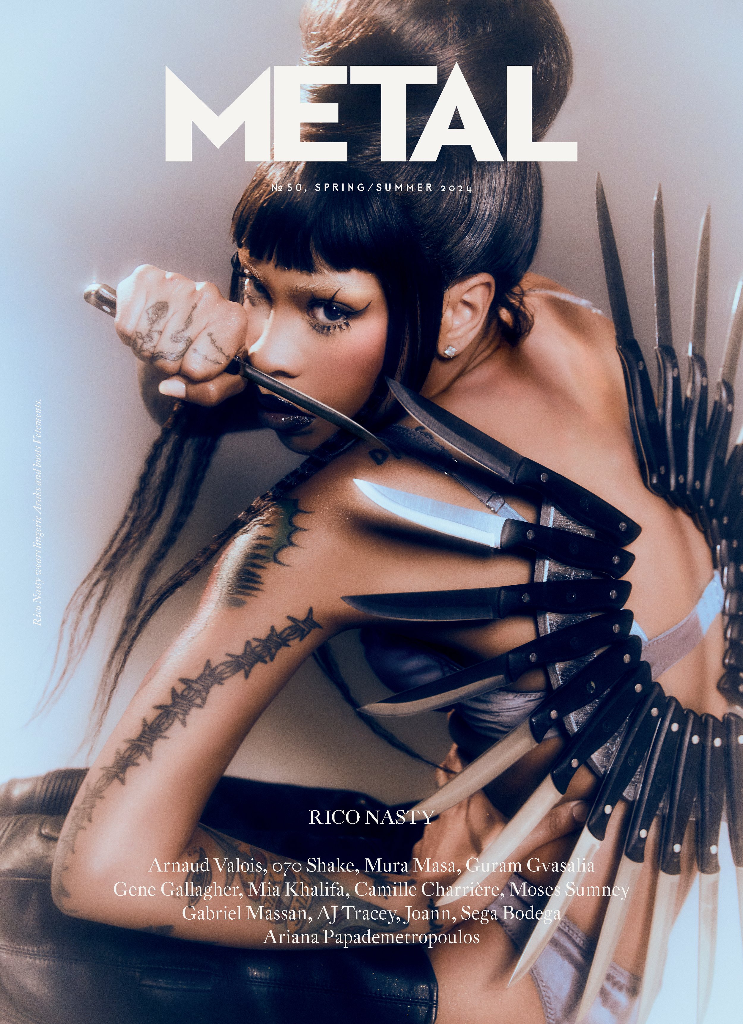 Metal Magazine cover featuring Rico Nasty with knives; wearing black eyeliner, a high bun hairstyle, and barbed wire tattoo design on the arm.