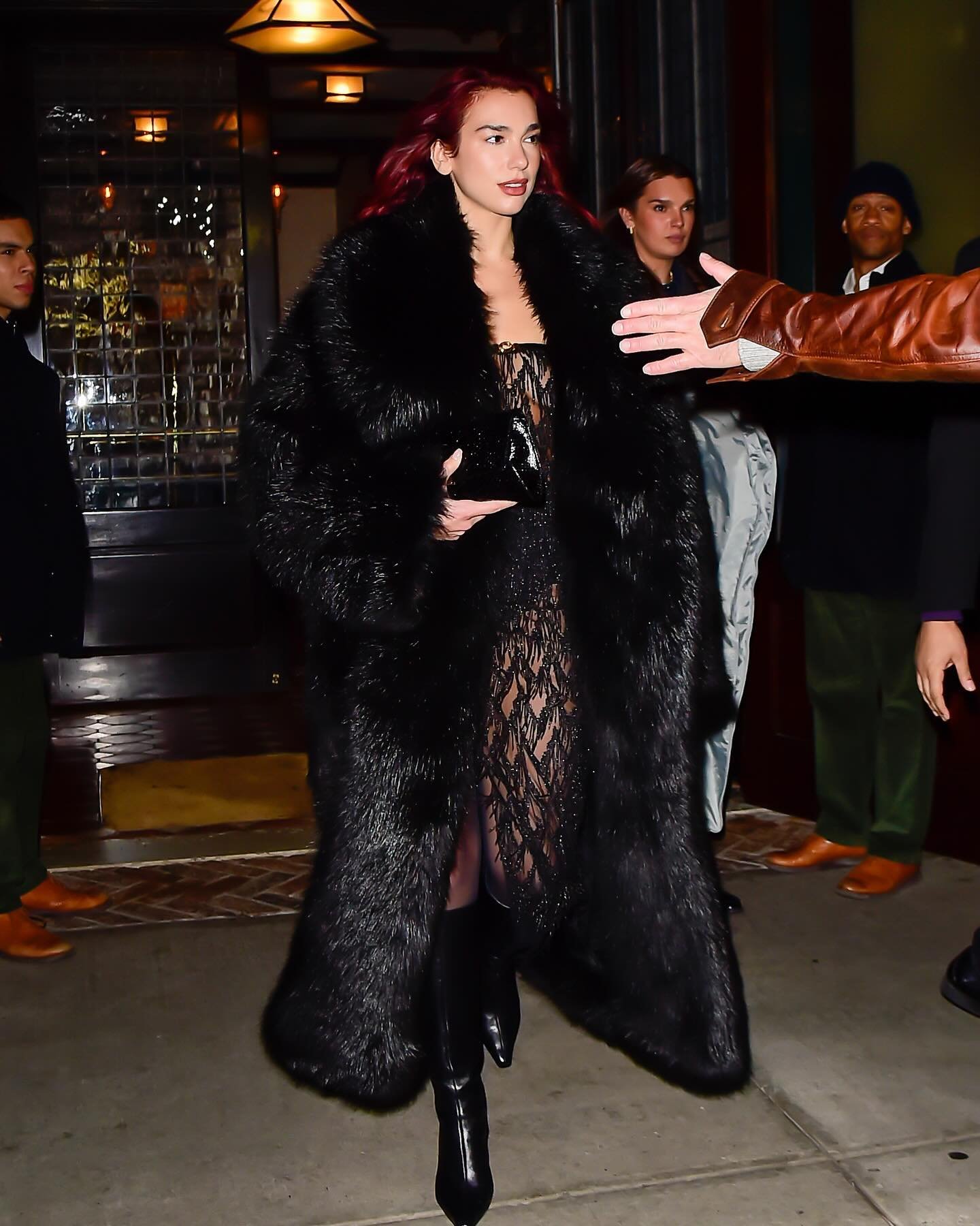 Dua Lipa wearing a black faux fur coat and lace dress styled by Lorenzo Posocco in Milan